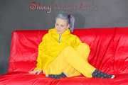 MARA wearing a sexy yellow shiny nylon rain suit lolling and posing on a bed (Pics)