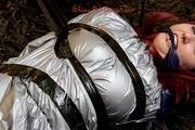 Mara tied and gagged with tape on bed wearing s shiny silver PVC sauna suit (Pics)