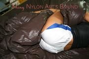 Stella tied and gagged in bed wearing shiny nylon shorts and a black top (Pics)