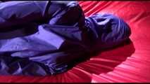 Sonja tied and gagged with ropes and a ballgag on a bed covered with a red shiny nylon cloth wearing a blue shiny nylon rain pants and a purple rain jacket (Video)