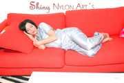 ENNI putting on a very sexy grey shiny nylon adidas rain catsuit and lolling and posing on a sofa (Pics)