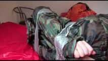 Mara taped, gagged and hooded on bed wearing a sexy shiny camouflage rainwear (Video)