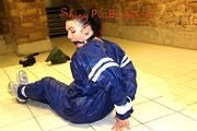 Jill tied and gagged in an old cellar on the floor wearing a shiny blue PVC sauna suit (Pics)