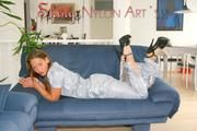 Stella posing in a living room wearing a supersexy grey rainwear jumpsuit (Pics)