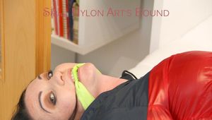 Jill tied and gagged on a white sofa wearing a lightblue nylon shorts and a red/darkblue rain jacket (Pics)