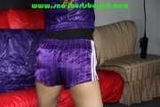 Sandra being tied and gagged overhead with ropes, a bar and a ballgag wearing sexy purple shiny nylon shorts and rain jacket (Pics) 