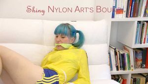 Mara tied and gagged with ropes and cloth gag on a sofa wearing a sexy blue shiny nylon shorts and a yellow/black oldschool rain jacket (Pics)