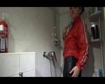 Mara wearing a very special red rain jacket and a darkblue rain pants enjoying herself and the cloths during taking a shower in it (Video)