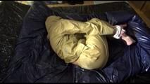 Pia tied, gagged and hooded lying on a bed wearing sexy golden rainwear (Video)