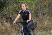 Watch Sandra riding and checking her Bike wearing a shiny nylon Jumpsuit