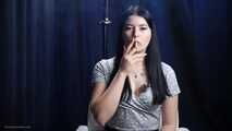 Brunette with mysterious look smoking all white cigarette