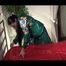 Lucy wearing green rainwear while putting on clean shiny nylon linen (Video)