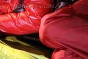 Watching sexy Jill wearing a red shiny nylon rain pants and an oldschool rain jacket under a red downjacket being tied and gagged with ropes and a ballgag on a bed (Pics)