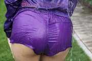 Watching sexy Aiyana wearing a sexy purple shiny nylon shorts and a purple shiny nylon rain jacket enjoying the garden shower (Pics)