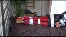 Mara tied and gagged on bed with tape, cuffs and a cloth gag wearing a black/red crazy sensation downwear (Video)