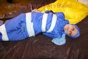 Lucy taped, hooded and gagged on bed wearing sexy blue rainwear (Pics)