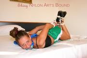 Stella tied and gagged on a bed in an hotel wearing a sexy green shiny nylon shorts and a top (Pics)