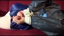 Lucy tied and gagged on a red sofa wearing a supersexy blue shiny nylon shorts and a blue rain jacket (Video)