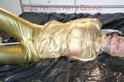 Pia tied, gagged and hooded on bed wearing a sexy golden rain combination and wings (Pics)