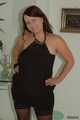 Chubby Benita posing in a black dress, stockings and heels