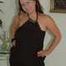 Chubby Benita posing in a black dress, stockings and heels