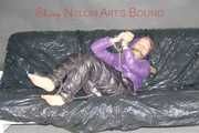 Sandra tied and gagged on a sofa with cuffs and a pillory wearing hot purple down jacket and black down pants (Pics)