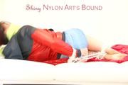 Jill tied and gagged on a white sofa wearing a lightblue nylon shorts and a red/darkblue rain jacket (Pics)