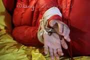 Watching sexy Jill wearing a red shiny nylon rain pants and an oldschool rain jacket under a red downjacket being tied and gagged with ropes and a ballgag on a bed (Pics)