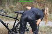 Watch Sandra riding and checking her Bike wearing a shiny nylon Jumpsuit