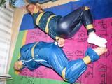 Stella and Leonie tied and gagged and hooded with tape both wearing sexy shiny nylon rainwear (Pics)