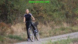 Watch Sandra riding and checking her Bike wearing a shiny nylon Jumpsuit