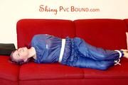 Mara tied and gagged on a sofa wearing a shiny blue PVC sauna suit (Pics)