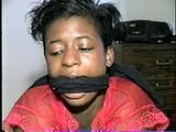 BLACK SHONDA IS RUBBER BAND BALL-GAGGED, MOUTH STUFFED, CLEAVE GAGGED & TIED BACKWARDS ON A CHAIR (D36-15)