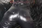 Lucy wearing a supersexy black rain catsuit posing and lolling on a sofa (Pics)
