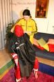 Jill tied, gagged and double hooded on a chair by an archive girl both wearing shiny rainwear (Pics)