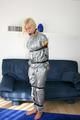 Blond-haired maid tied and gagged with tape wearing a shiny silver PVC sauna suit (Pics)