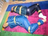 Stella and Leonie tied and gagged and hooded with tape both wearing sexy shiny nylon rainwear (Pics)