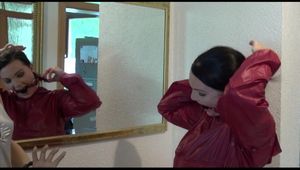 Jill ties, gagges and hoodes herself in front of a mirror and in an strairway wearing a sexy shiny nylon rain pants in black and a red rain jacket (Video)