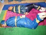 Stella and Leonie tied and gagged and hooded with tape both wearing sexy shiny nylon rainwear (Pics)