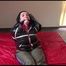 Jill tied, gagged and hooded on bed wearing a sexy shiny black downjacket with a closed hood (Video)