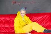 MARA wearing a sexy yellow shiny nylon rain suit lolling and posing on a bed (Pics)