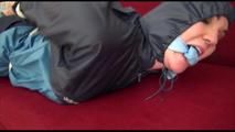 Jill tied and gagged on a sofa wearing a sexy shiny blue adidas shorts and a blue rain jacket (Video)