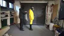 See Lady M, bound in shiny yellow Rainsuit, wearing a latex Mask and a Gasmask