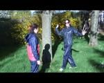 Jill and a friend of her playing with eachother in the garden while wearing shiny nylon rainwear (Video)