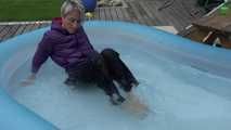 Watching sexy Sonja wearing a sexy shiny nylon rain pant and a purple down jacket enjoying the water in the swimming pool (Video)