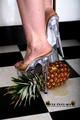 Heels crushing pineapple in the kitchen