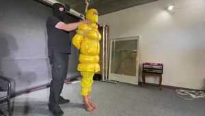 Ms Ungeniert tied, gagged and hooded in shiny nylon yellow Downjacket