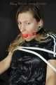 Sexy Sandra being tied and gagged on a haircutter`s chair with ropes and a ball gag wearing a supershiny sexy black rain bib overall (Pics)