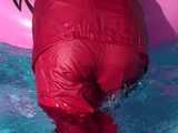 Watch Sandra watering the garden and wetting her shiny nylon oldschool Rainsuit in the Pool