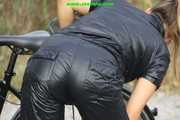 Watch Sandra riding and checking her Bike wearing a shiny nylon Jumpsuit